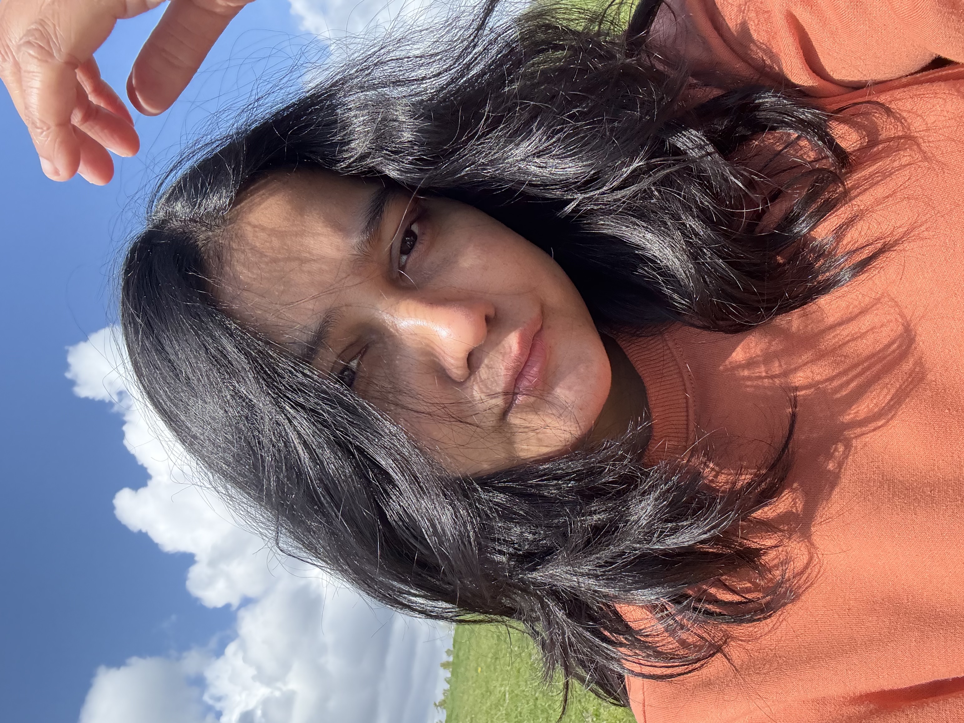 Portrait in a grassy field under a blue sky